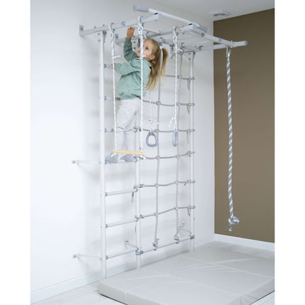 Child climbing indoor play gym with rope ladder and rings on Swedish Giant Wallbars - S7 in sensory playroom