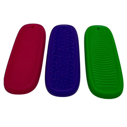 Three colorful Tac Tiles sensory fidgets in red, purple, and green with different textured surfaces.