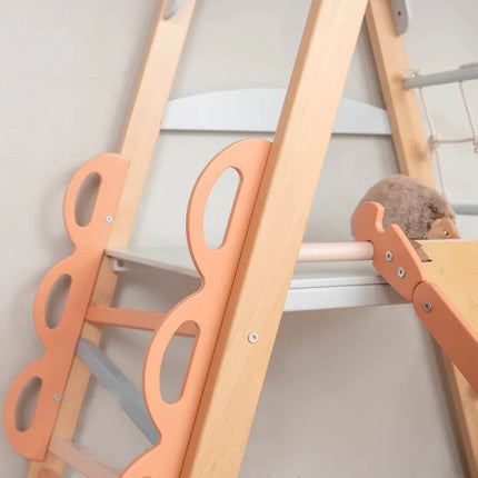 Close-up of wooden climbing frame with peach handles and ropes in the Wooden Teepee Playground set designed for sensory play.