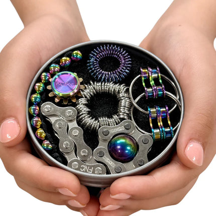 Hands holding The Works Fidget Kit with metallic sensory tools in oil slick colors arranged in a round tin case