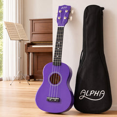Alpha 21 Inch Ukulele Soprano Beginner Acoustic Small Guitar Kids Strings Purple with black soft carry case, piano background.