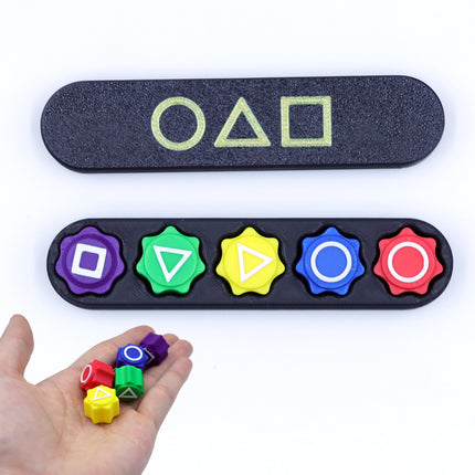 Squid Game 2 Gonggi & Case Korean Grab 5 stone sieves+rectangular box held in hand with colorful symbols on black case helping families thrive.
