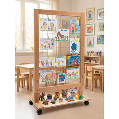 Rolling classroom art display rack with children's drawings and crafts, surrounded by tables and framed artwork