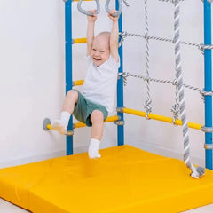 Child playing on indoor climbing frame above bright yellow Super Soft Foldable Landing Play Mats for safety and comfort.