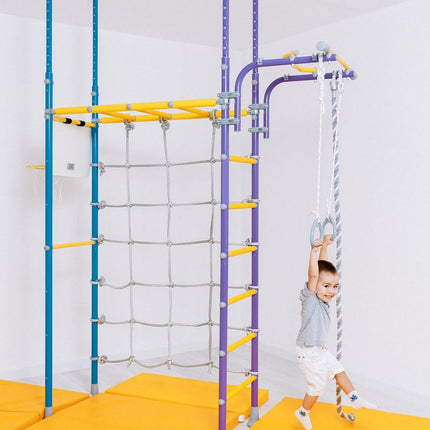 Child playing on colorful indoor Swedish Home Play gym set - No Drill with climbing rope and gymnastic rings, helping families thrive.