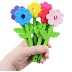 Hand holding colorful flower-shaped sensory chew toys called ARK's Flower Wand Chewy in various colors.
