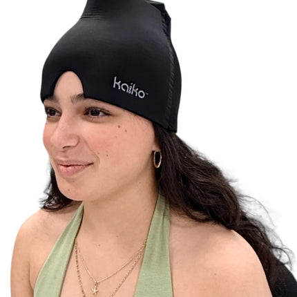 Woman wearing a black Block Out Cooling Head Mask – a cool ‘hug’ for your head, smiling softly against white background