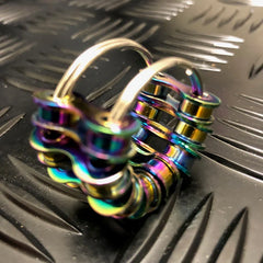 Close-up of a colorful metal Caged Fidget placed on textured black surface, designed for sensory and focus aid.