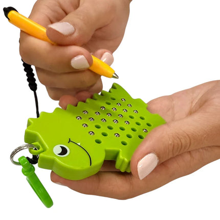 Dinosaur Magnetic Pad Keyring in bright green held in hands with small magnetic balls and a yellow stylus for tactile play and sensory stimulation.