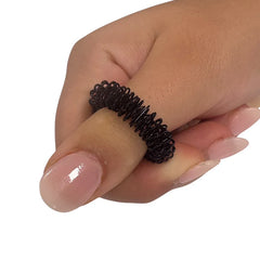 Hand wearing a black flexible sensory ring called Standard Finger Spikey for tactile stimulation and focus aid.