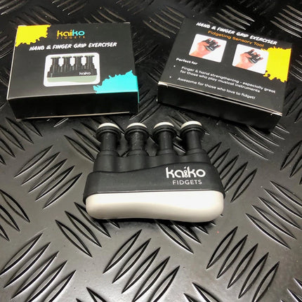Hand & Finger Grip Exerciser & Fidgeting Sensory Tool with black and white design, displayed with packaging on black textured surface.