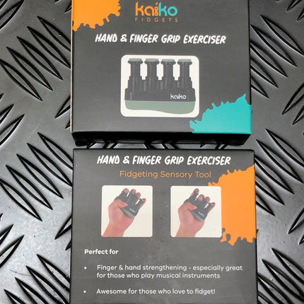 Two black boxes of Hand & Finger Grip Exerciser & Fidgeting Sensory Tool, showing product image and usage instructions on textured dark metal surface.