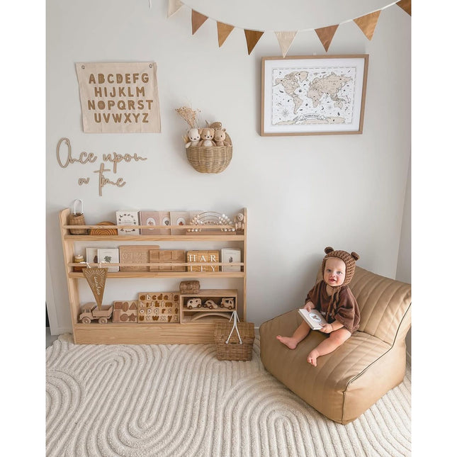 JORY 3 — Front-Facing Bookshelf in a cozy child’s room with educational toys and a baby in a bear costume reading.