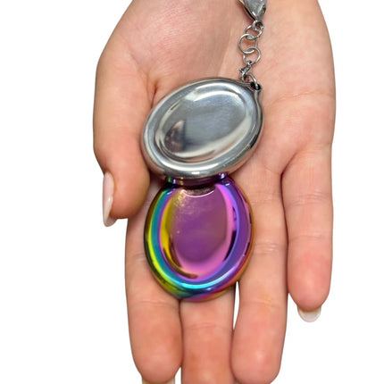 Hand holding Groove Stone - Dual Support Necklace & Key Chain with silver and iridescent oval stones on keychain.