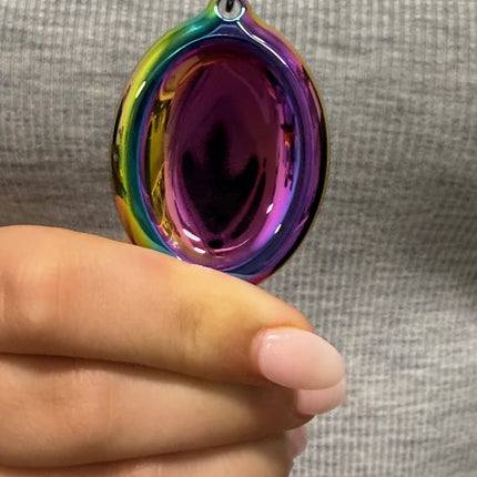 Hand holding a colorful iridescent fidget toy necklace with Groove Stone - Dual Support Necklace & Key Chain text.