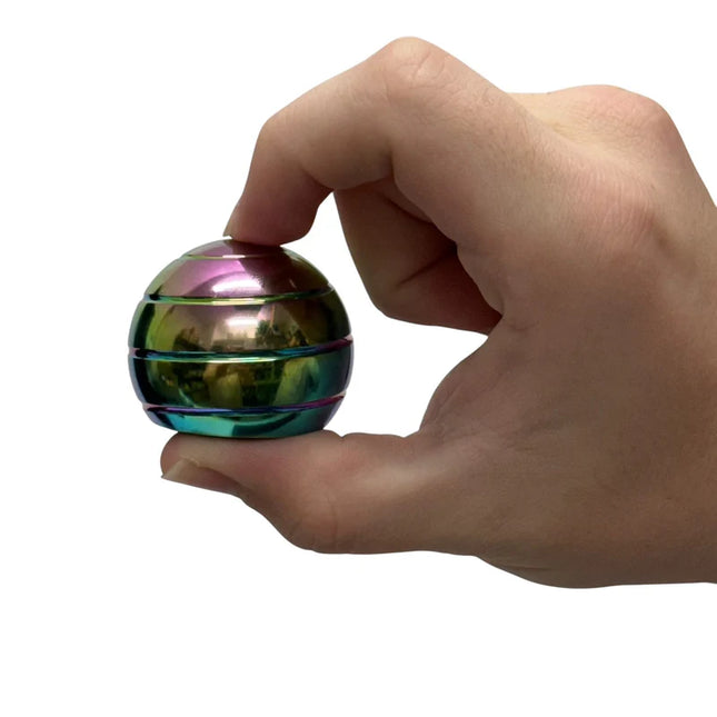 Hand holding a small iridescent metallic sphere labeled Gyroscope - 70gm against white background