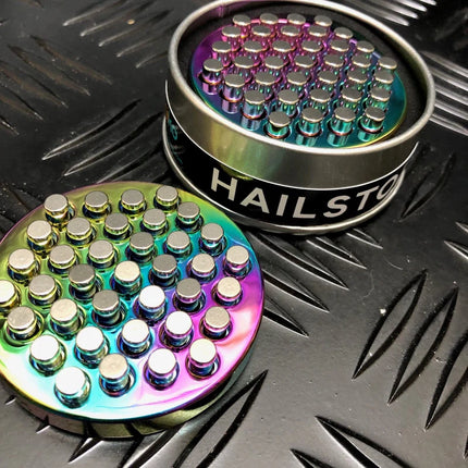 Hailstorm ASMR Fidget - Kaiko Exclusive metal sensory fidget with rainbow colors on textured surface background