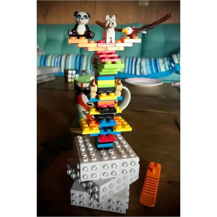 Colorful stacked toy made of interlocking bricks with animal figures on top, showing Brick Style Cube play.