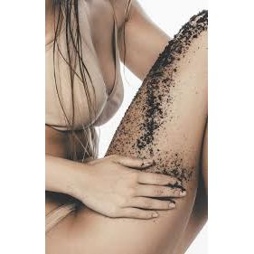 Woman applying Coffee Body Scrub Original Warm Vanilla Blend to leg, promoting calm, connection, and support for families.