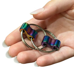 Hand holding Luxe Loop sensory fidget with colorful metal rings designed for tactile stimulation and focus aid