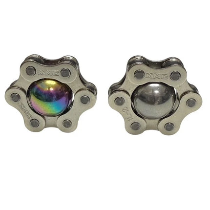 Two metallic star-shaped Magic Ball Fidget by Kaiko with one ball showing a colorful oil slick finish and the other plain silver.
