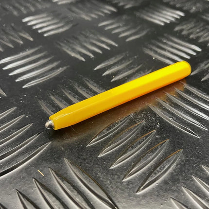 Yellow stylus pen resting on a textured metallic surface, designed for use with the Magnetic Pad - Original Rectangle Design.
