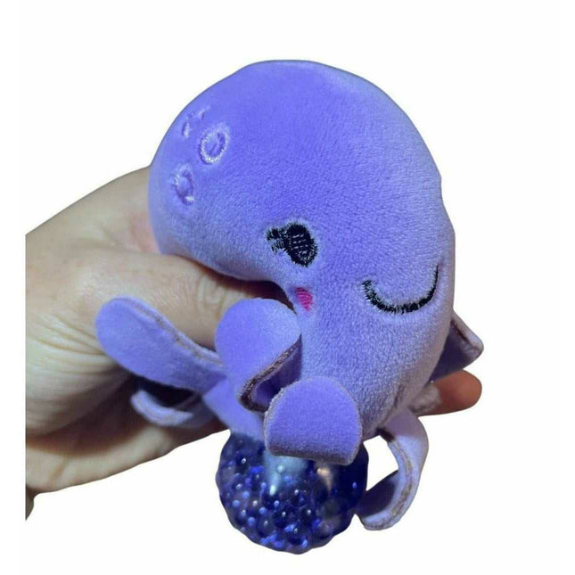 Hand holding a soft purple octopus toy with textured ball base from the Sea Animal Plush Ball Jellies collection