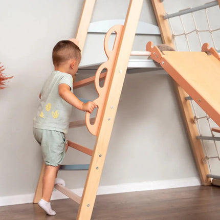 Child climbing a wooden play structure featuring a slide and rope ladder, Wooden Teepee Playground