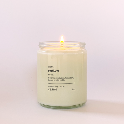 Lit NATIVES SINGLE WICKED SOY CANDLE (8oz / 226g) with calming scent notes of eucalyptus and frangipani. Helping families thrive.