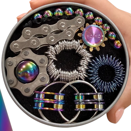 The Works Fidget Kit containing metallic rainbow-colored sensory and stress-relief tools in a round tin held by hand
