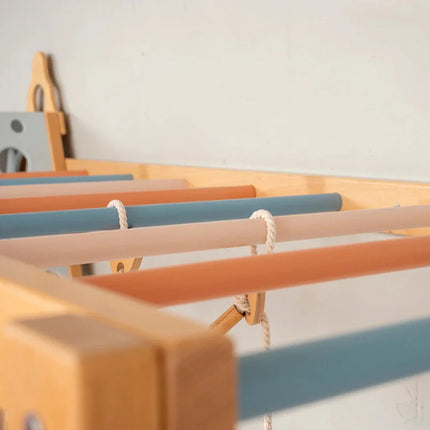 Close-up of colored wooden bars and ropes on a Wooden Teepee Playground sensory and educational toy structure.