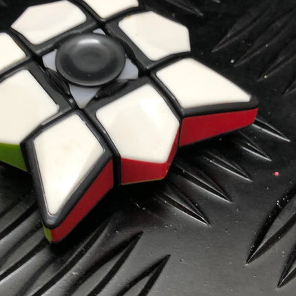 Yellow & White Cube Spinner on textured black surface, highlighting its geometric design and contrasting colors.