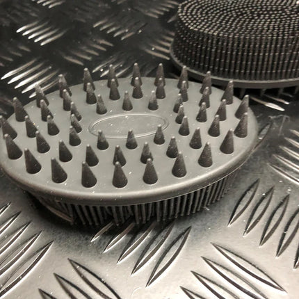 Black Tactile Sensory Brush with soft pointed bristles on textured surface for sensory and calming fidget use.