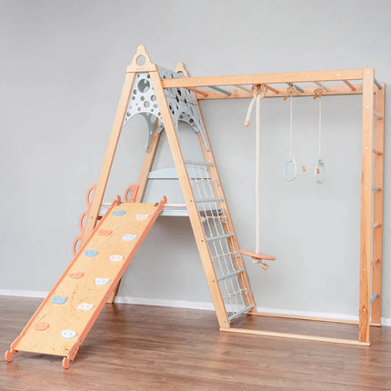 Wooden Teepee Playground with slide, climbing net, rope swing, and gymnastic rings in a minimalist room setting