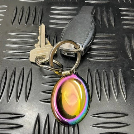 Groove Stone - Dual Support Necklace & Key Chain with iridescent oval charm attached to keys on textured black surface