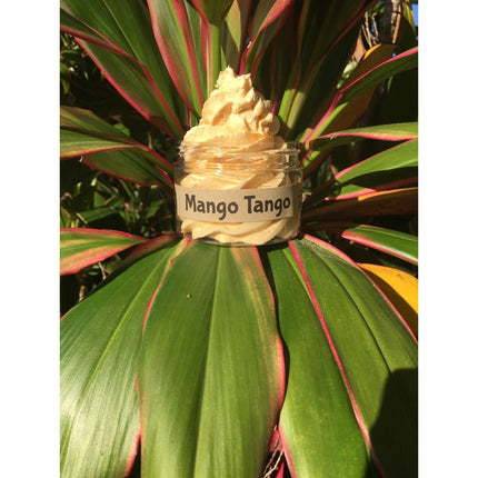 Mango Mango Whipped Body Cleanser jar with creamy texture on green tropical leaves, helping families thrive with tools to calm.